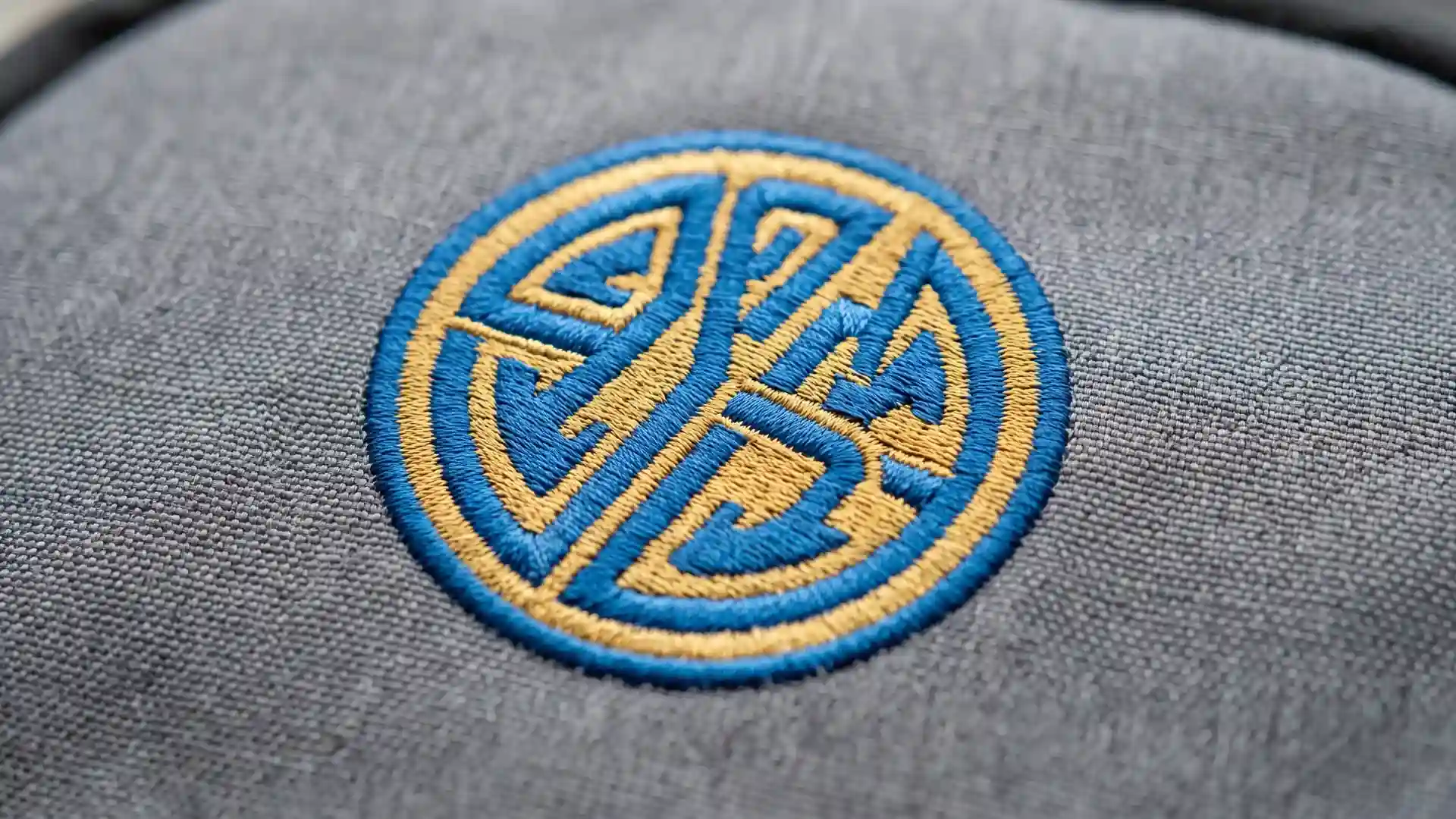 Close-up of a smooth-edged dense embroidered logo stitched on woven backpack fabric with no puckering, showing acceptable custom backpack logo methods quality.