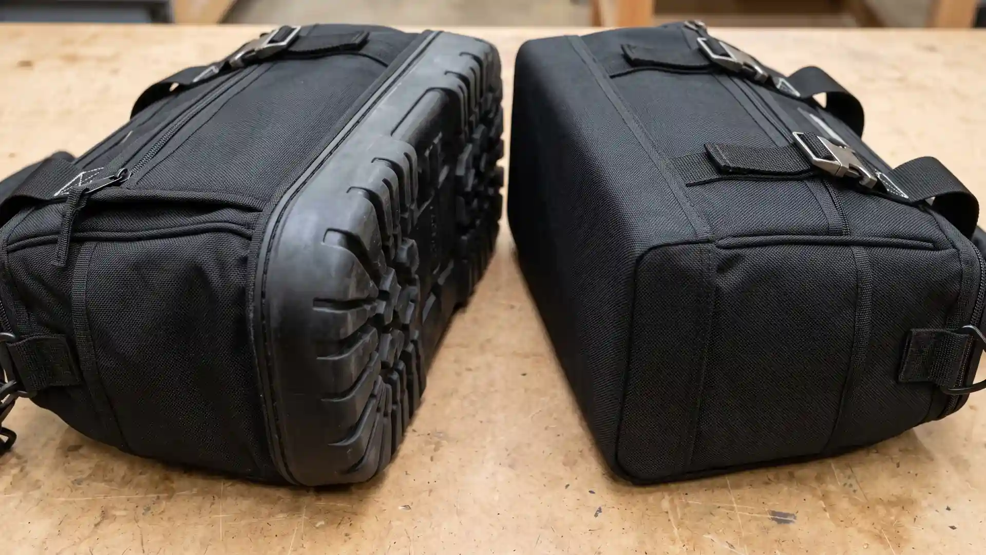 Molded rubber HVAC tool bag base and fabric-wrapped PE board base compared side by side on a workbench for field service bag durability.